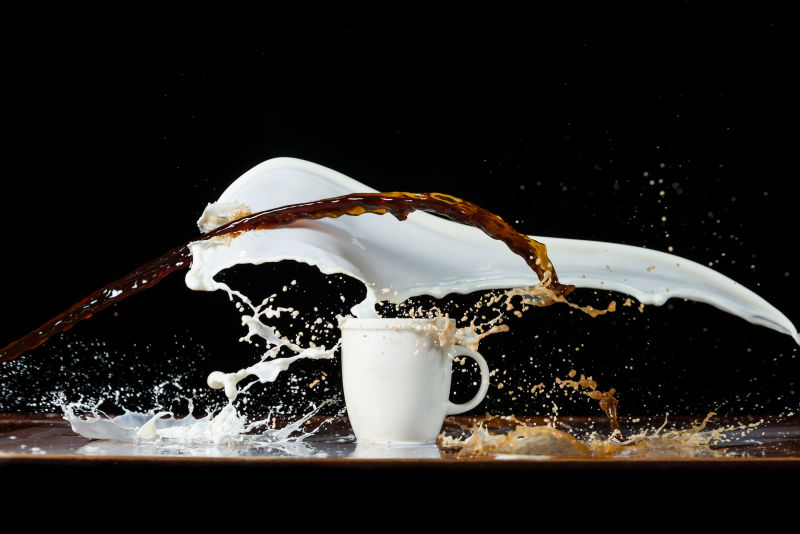 桌子上飞剑的牛奶咖啡和杯子