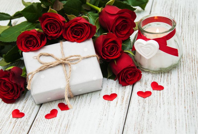 红玫瑰和木桌上的礼品盒