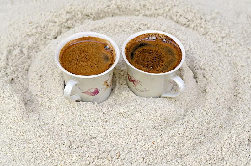 沙子上两杯咖啡