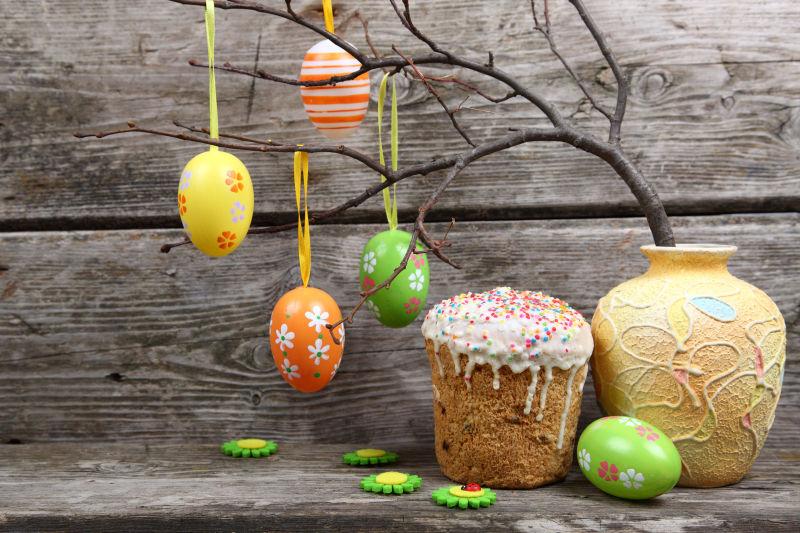 木质背景复活节彩蛋和糖霜蛋糕