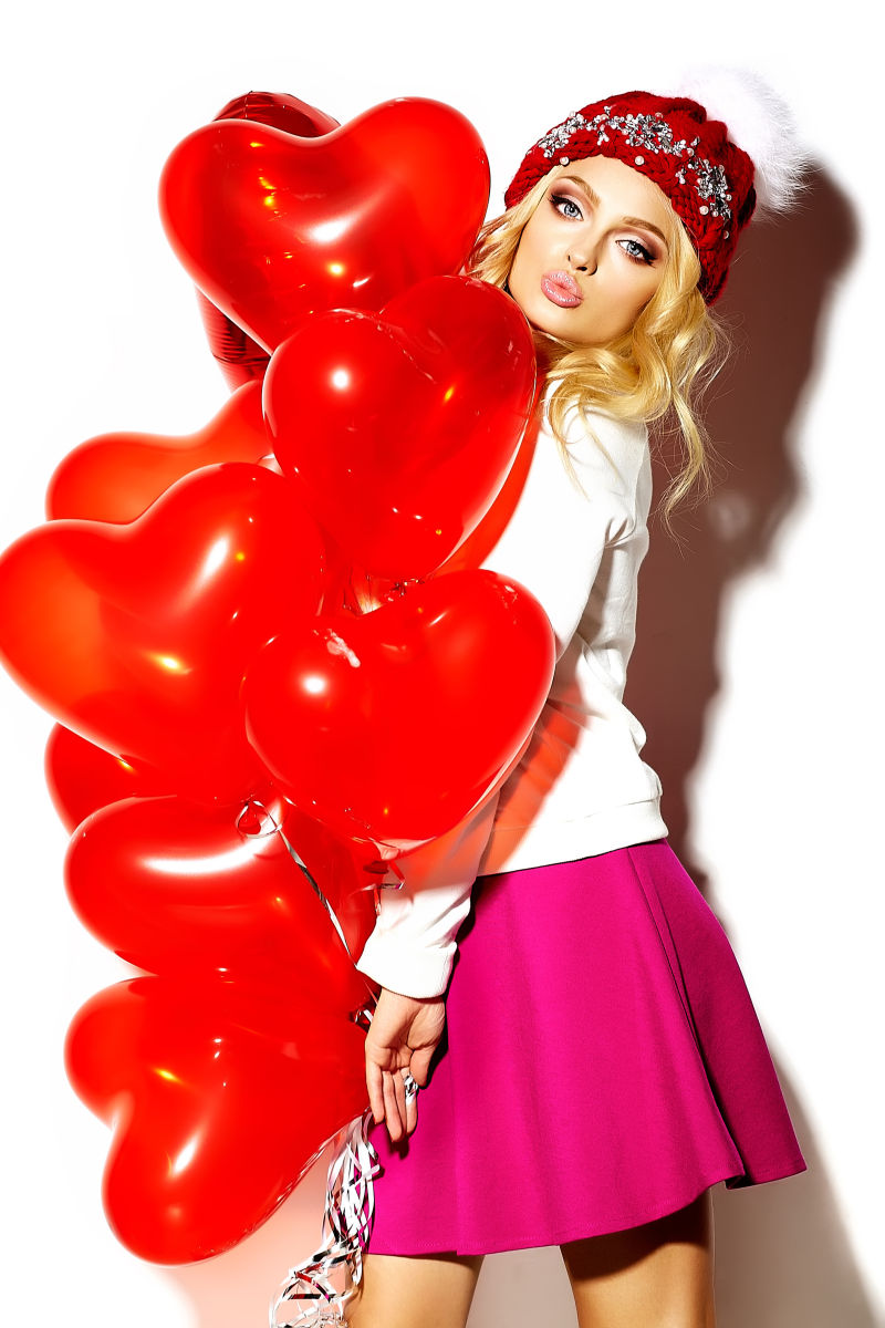 漂亮的美女抱着红色气球