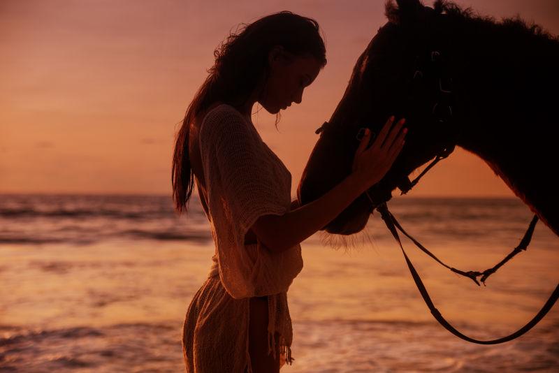 海边性感女人拥抱雄壮的种马