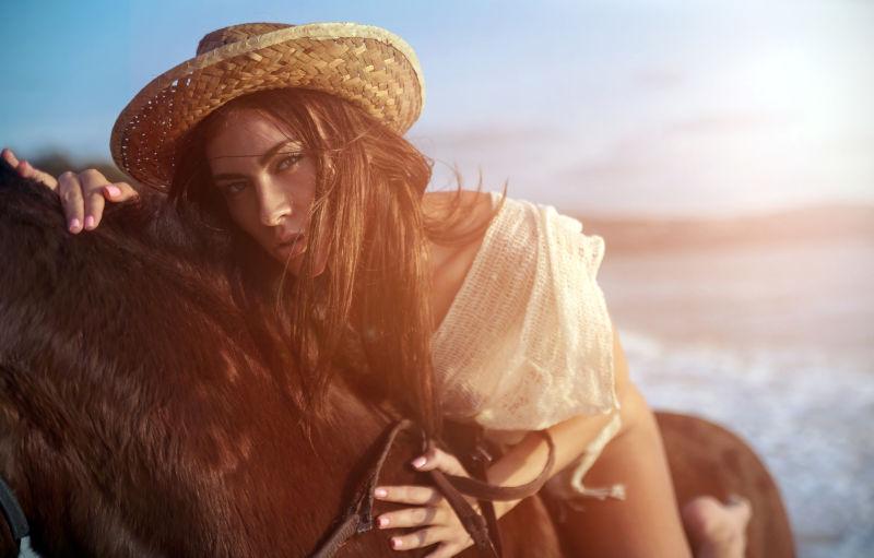 海边一位年轻迷人的女子骑着骏马