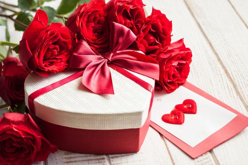 木桌上的玫瑰花束和情人节礼物
