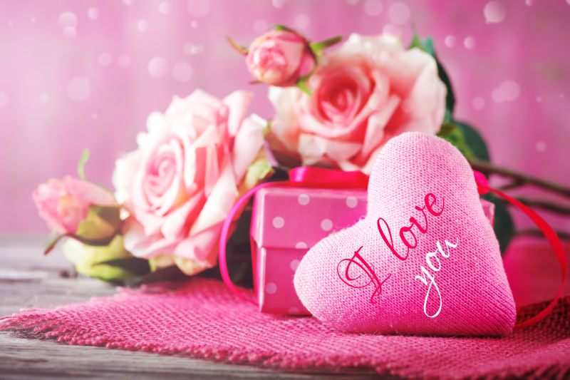 木桌上的粉色玫瑰花和情人节礼物