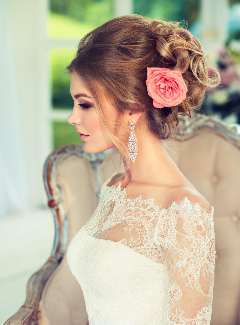 美丽的新娘头上别着一朵粉色鲜花