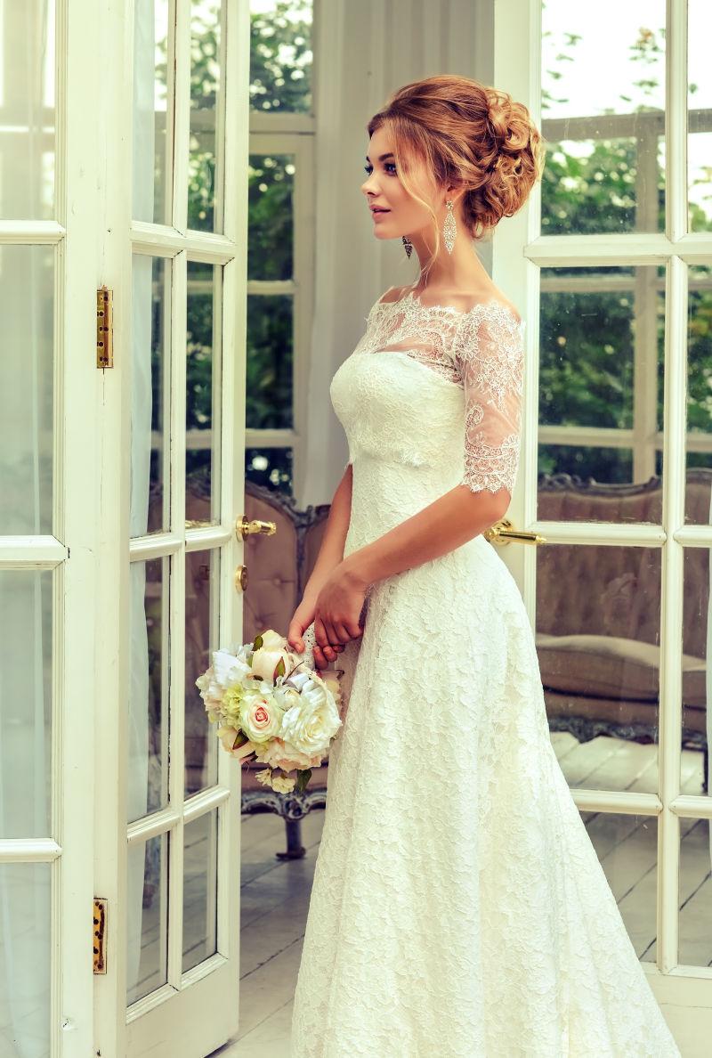 穿着白色婚纱的新娘拿着一束手捧花