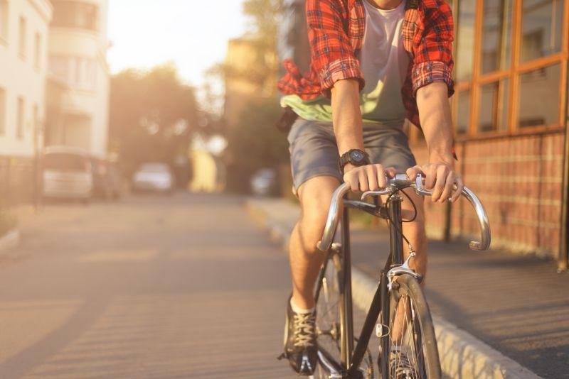 年轻男人日落下城市里骑自行车