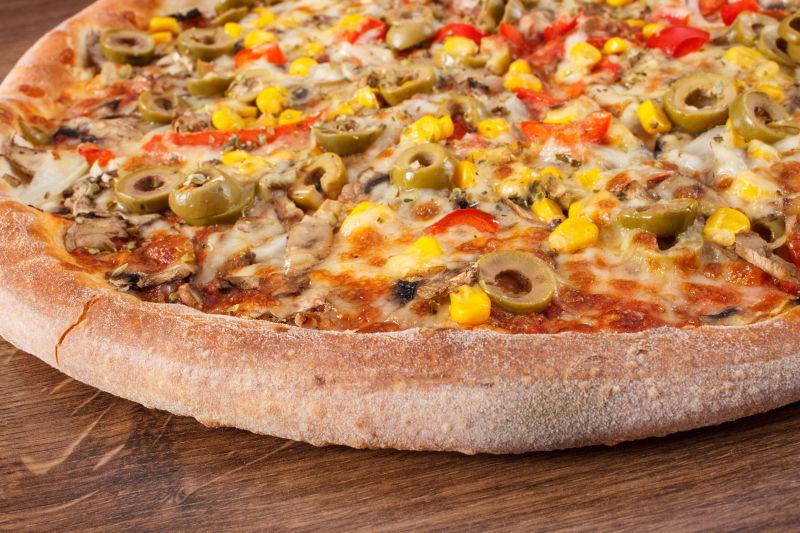 纯木制背景的素食披萨