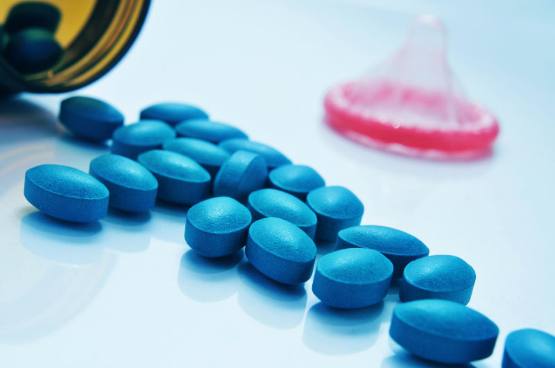 一堆蓝色药丸与避孕套