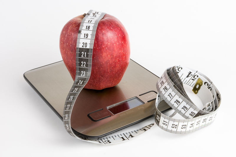 苹果重量秤和白色背景测量带