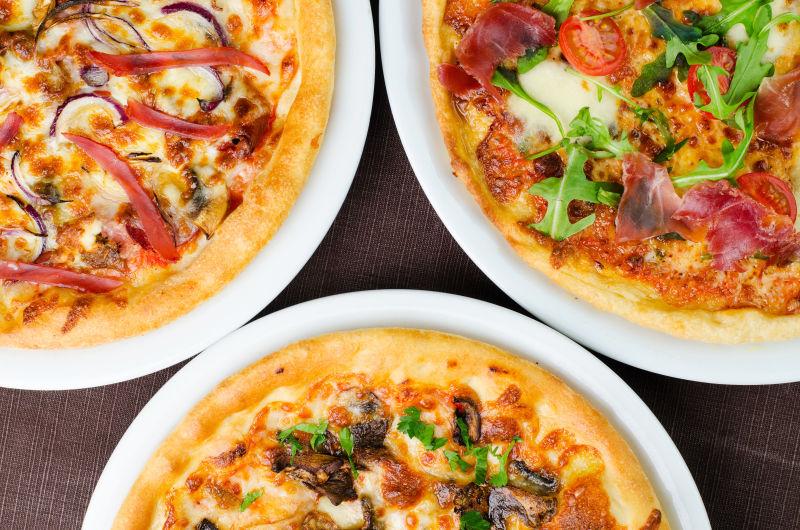 三种不同类型的美味比萨从上面特写镜头拍摄