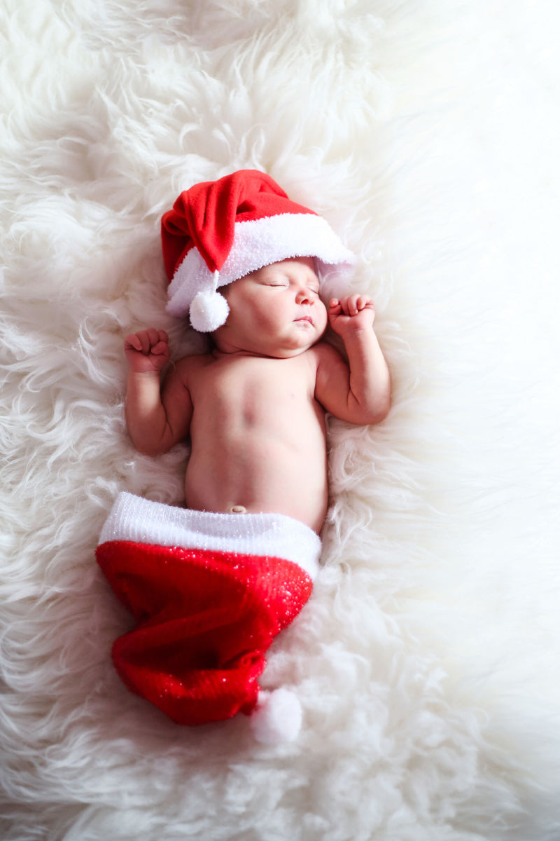 戴着圣诞帽子入睡的婴儿
