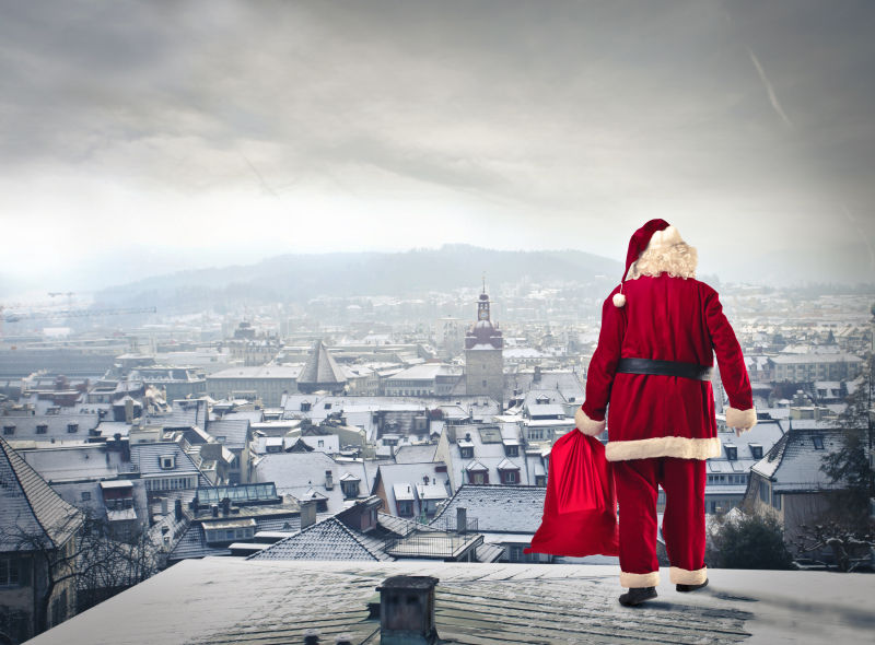 圣诞老人在城市房子的顶部