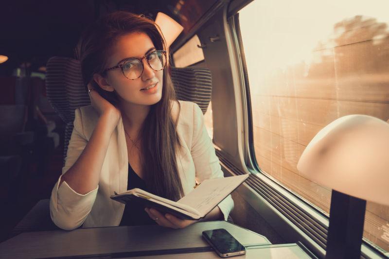 在火车上看书的戴着眼镜的美女