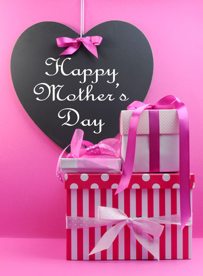 粉红条纹和圆点点缀着心形黑板的礼物带着母亲节快乐的信息