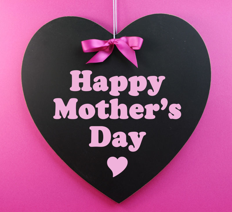 粉红色背景下的黑色心形母亲节快乐木板