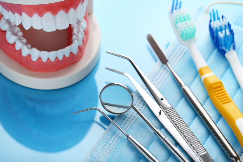 蓝色桌子上的牙科工具和牙齿模型