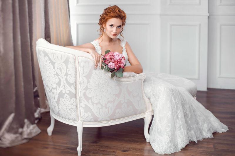 坐在椅子上的新娘拿着花束