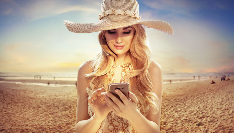 海滩上玩手机的美女