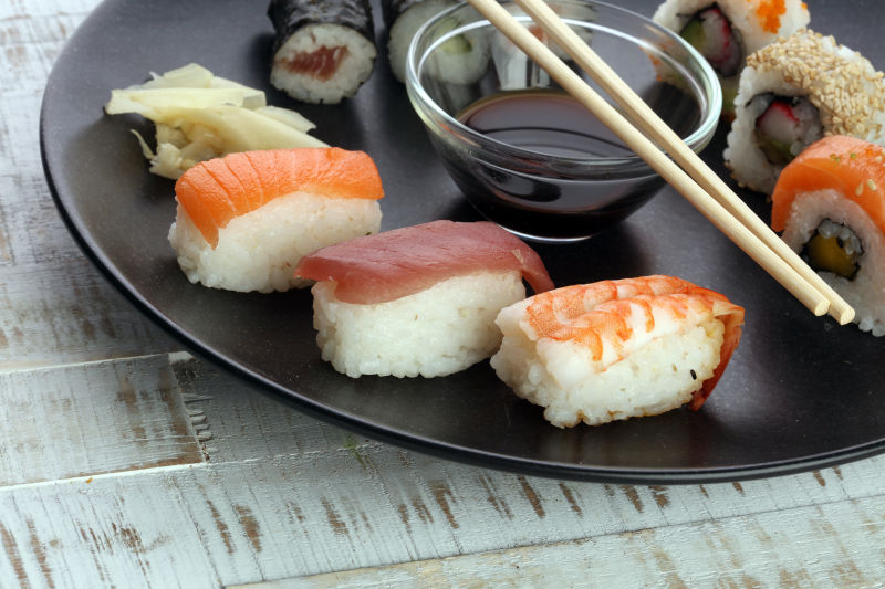 黑色盘子里的好吃的多种口味的寿司