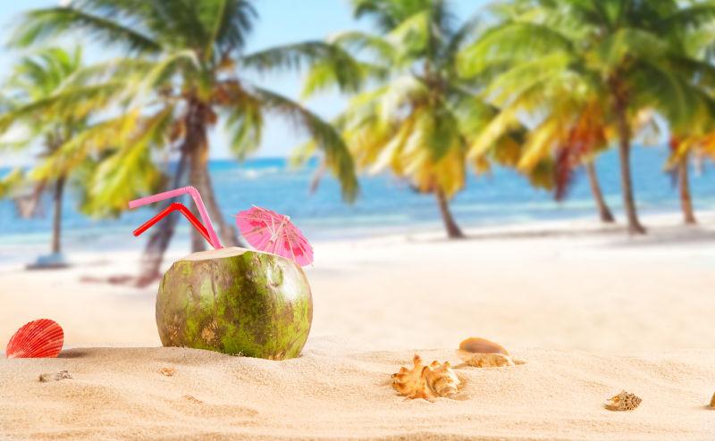 热带沙滩背景中的椰子鸡尾酒