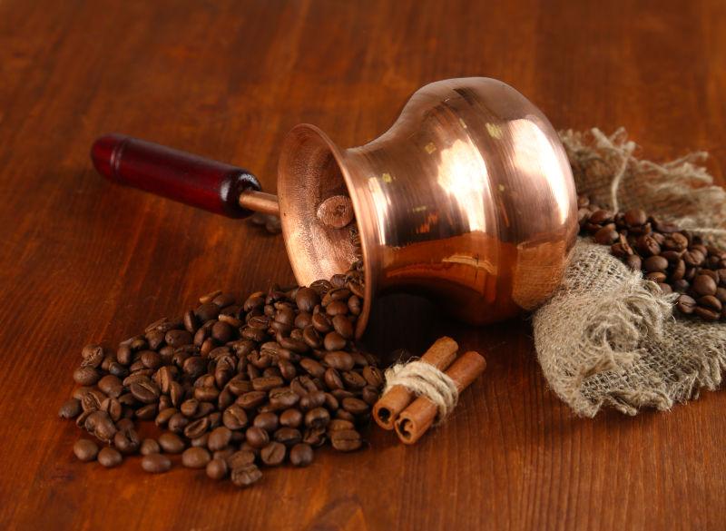 棕色木桌上的咖啡壶和咖啡豆
