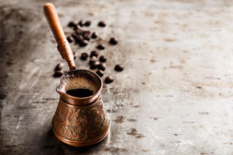 木桌上的铜咖啡壶和咖啡豆