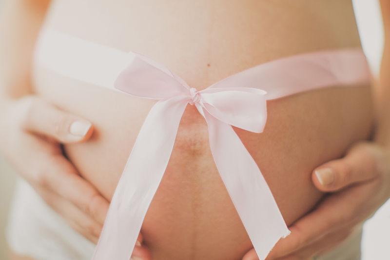 怀孕的孕妇肚子上的丝带