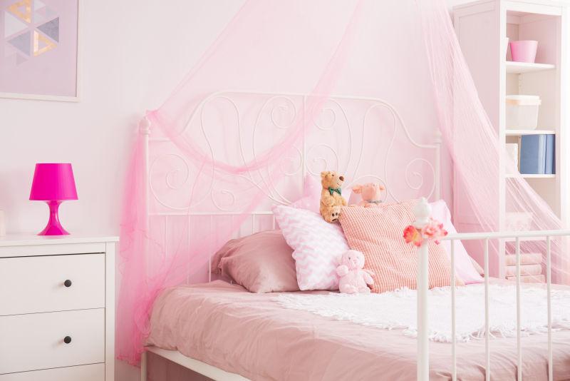 放着粉色小台灯的粉色主色调的女孩的卧室