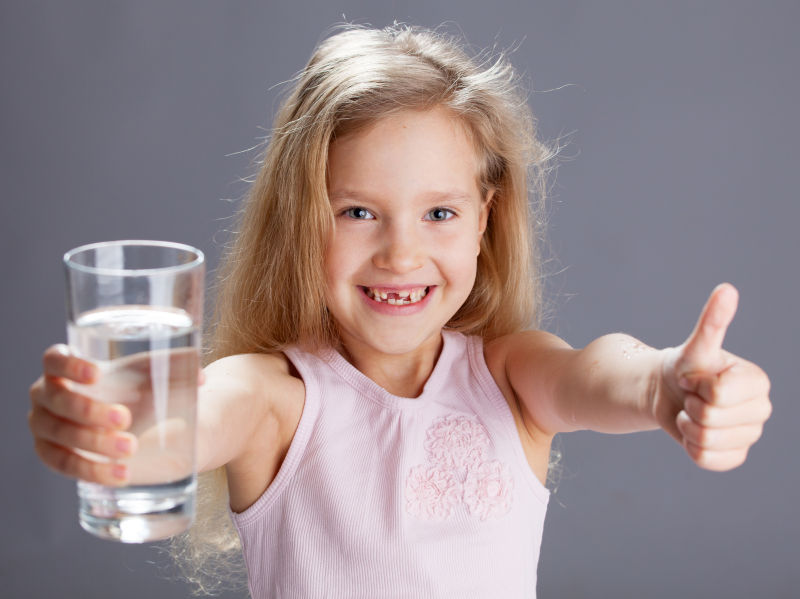 女孩从玻璃杯中喝水