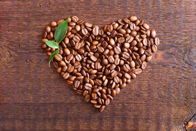 木桌上摆成心形的咖啡豆