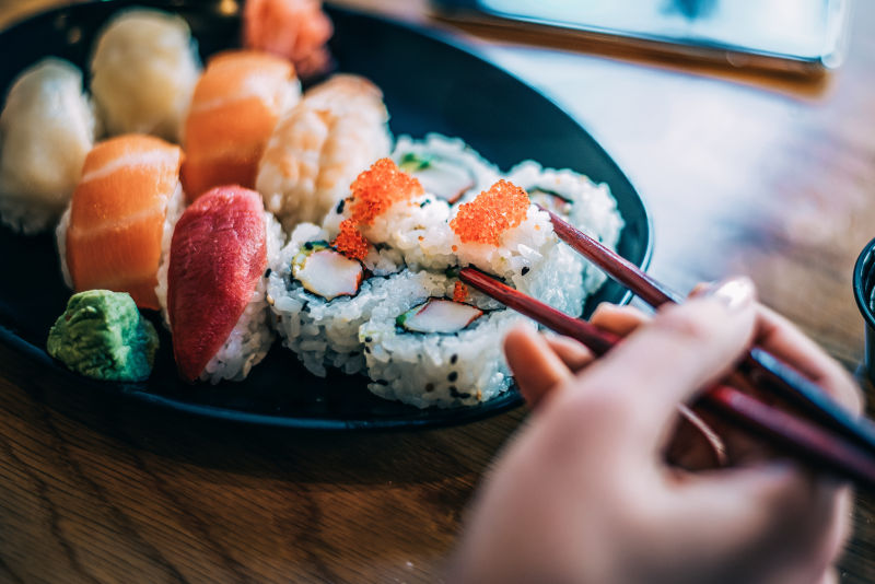 用筷子夹盘子里的寿司