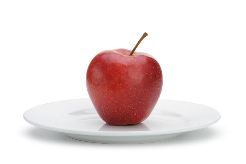 白色背景上餐盘里的红苹果