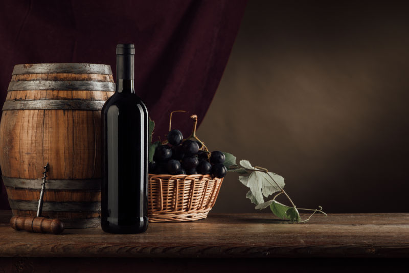 木桌上的葡萄酒与篮子中的葡萄