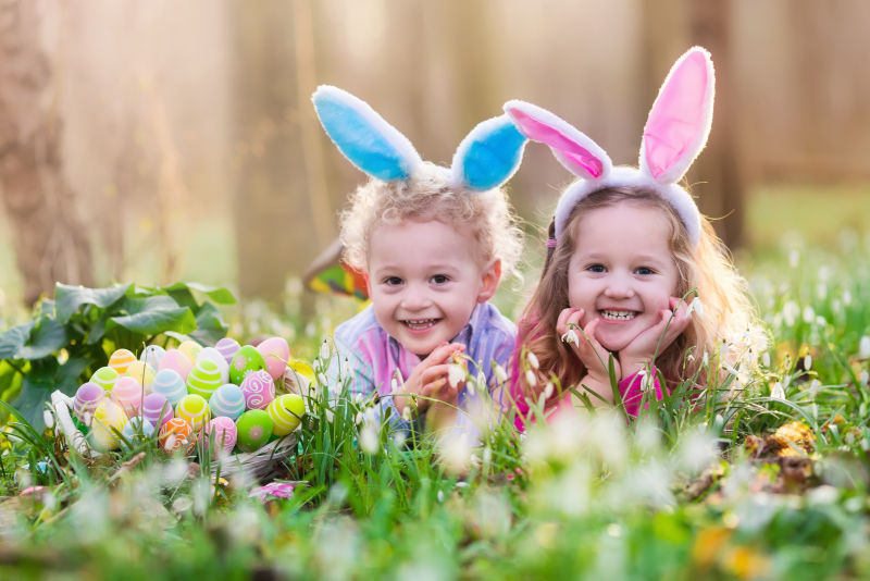躺在草坪上寻找复活节彩蛋的小孩子