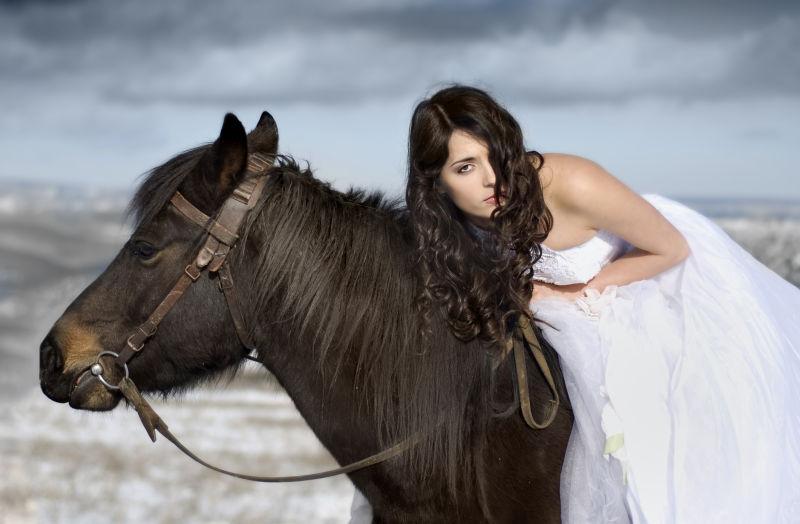 穿着婚纱骑在马背上的美女