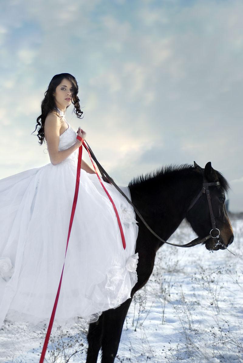 雪地里骑在马背上的美女