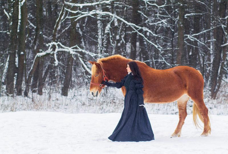 美丽的女人和冬天的马