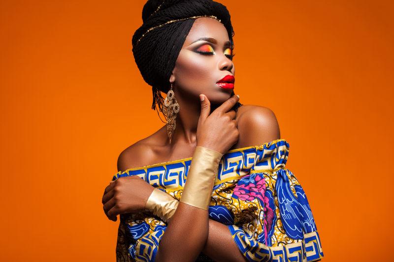 橙色背景下化妆的非洲女人