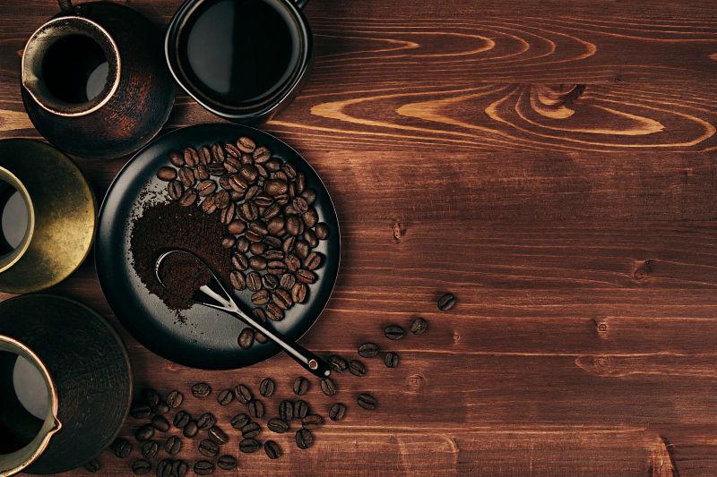 棕色的旧木板背景上的黑咖啡和咖啡豆