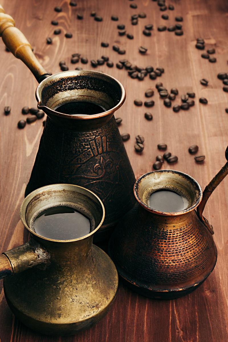 铜咖啡壶和木桌上的咖啡豆