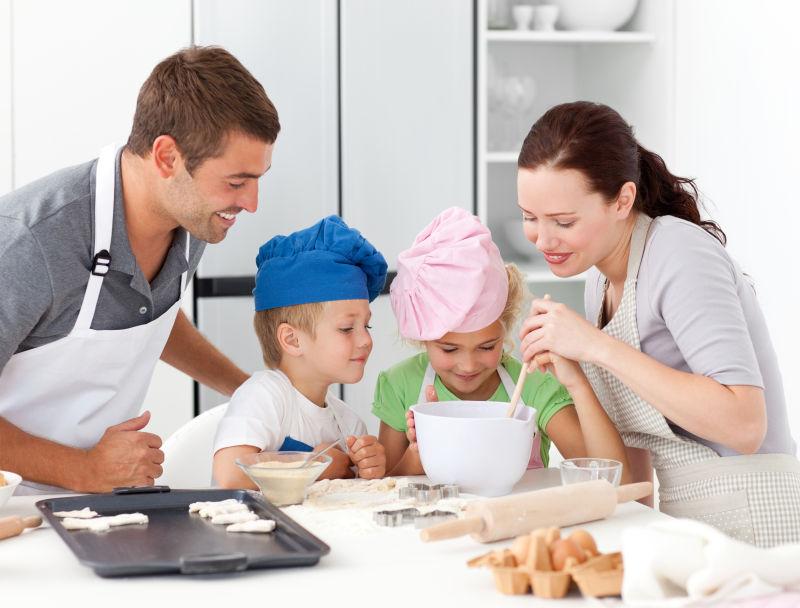 可爱的家庭在厨房一起烘烤美味饼干
