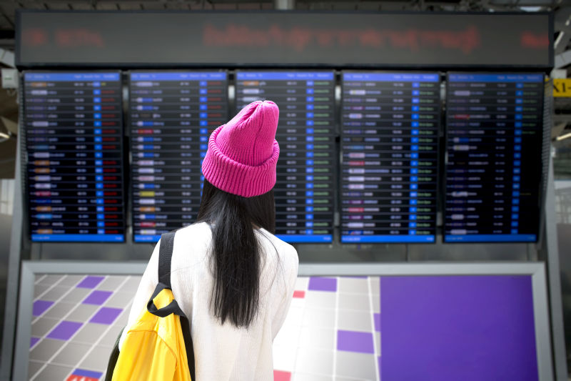 站在机场荧屏前的女人旅游