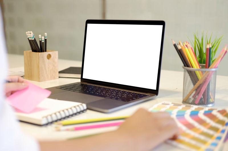 绘画设计师办公桌上的空白屏幕笔记本电脑