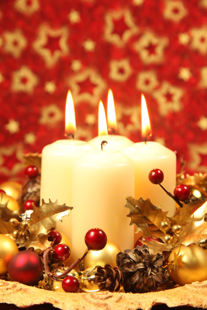 红色圣诞背景下有四支蜡烛