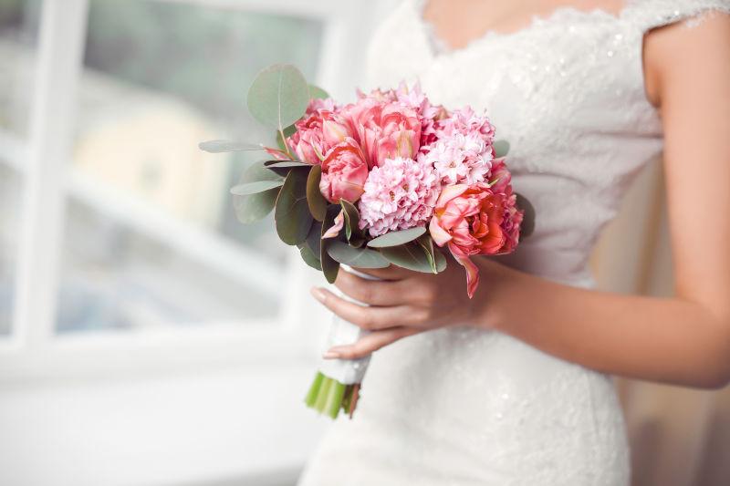 窗边的美丽新娘拿着手捧花