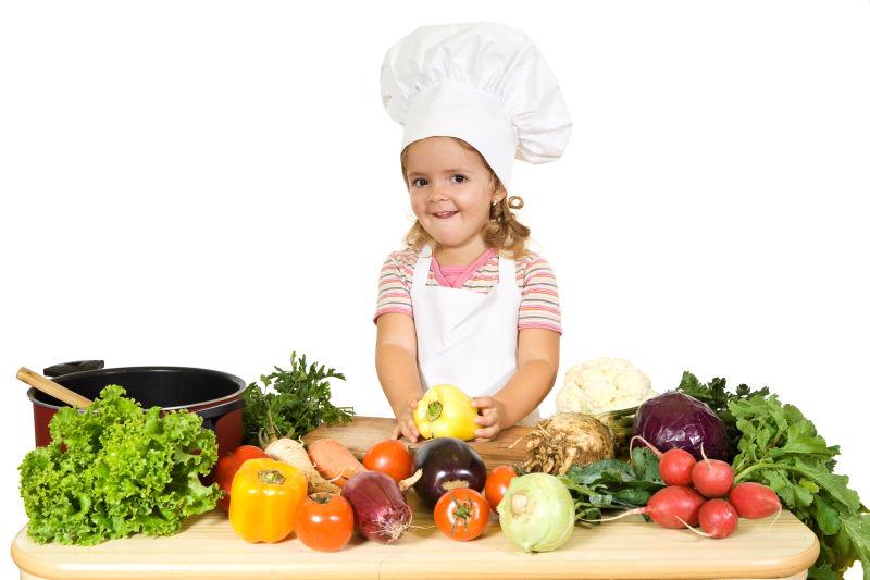 快乐的小女孩做厨师烹饪蔬菜