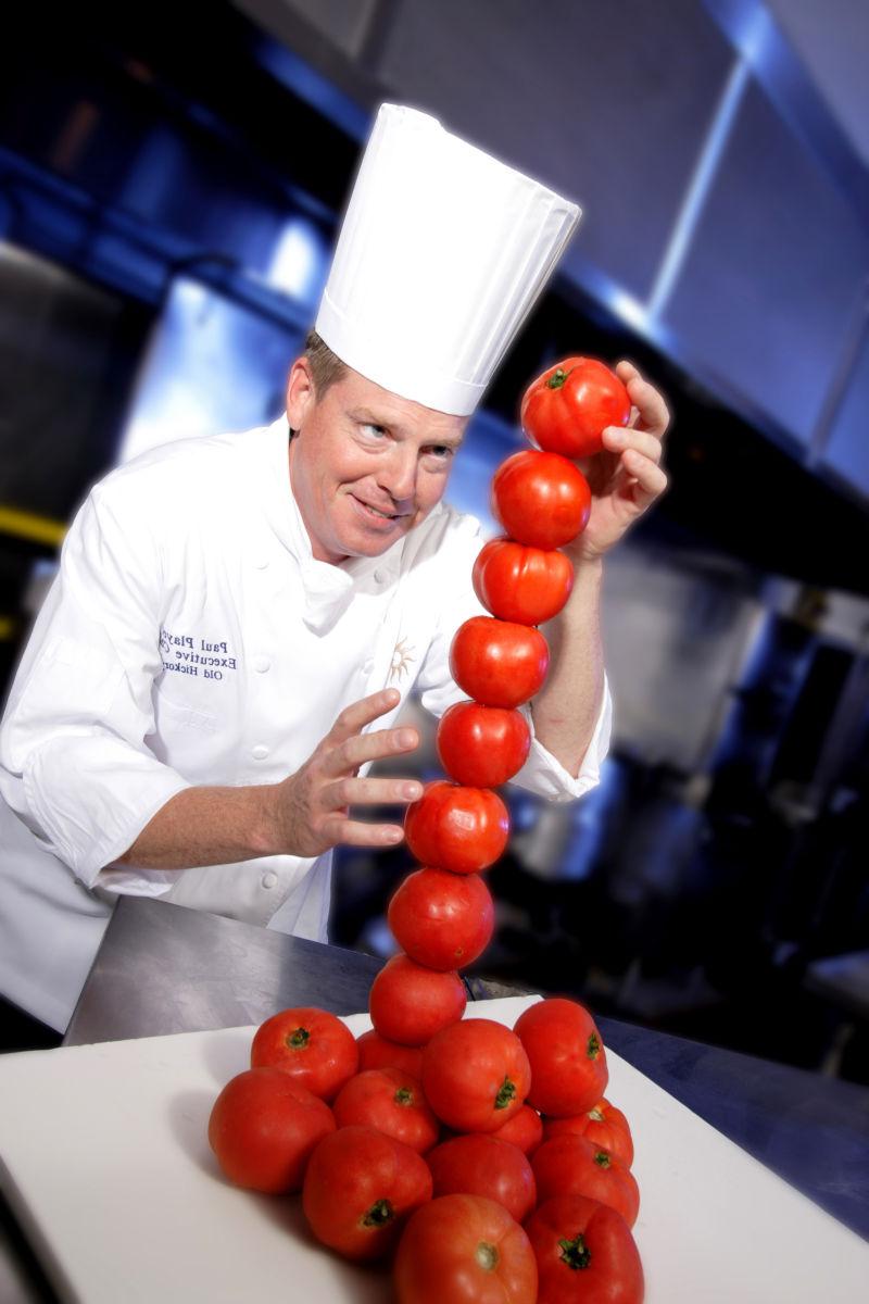 有趣的厨师在厨房垒番茄