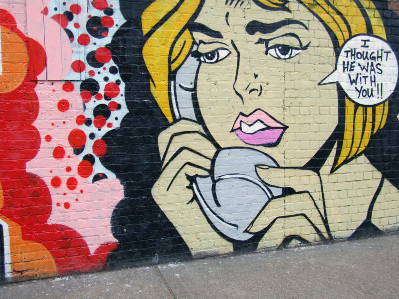 墙壁上一个女人在打电话的涂鸦